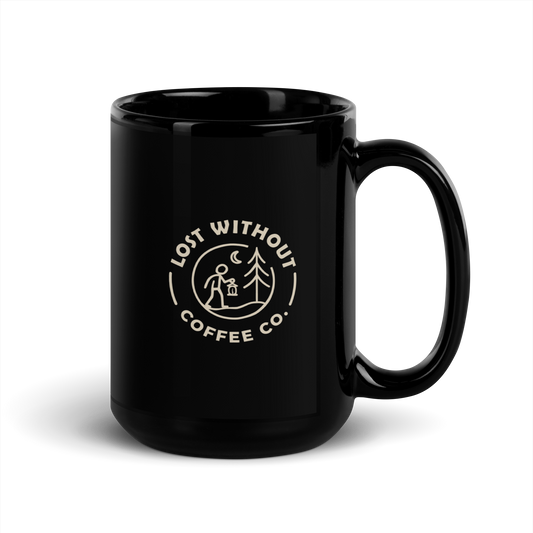 Black ceramic coffee mug with "Lost Without Coffee Co" logo and outdoor scene, ideal for coffee lovers.