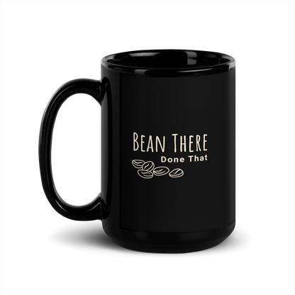 Black glossy coffee mug with "Bean There Done That" text and coffee bean graphic, perfect for tea or coffee lovers.